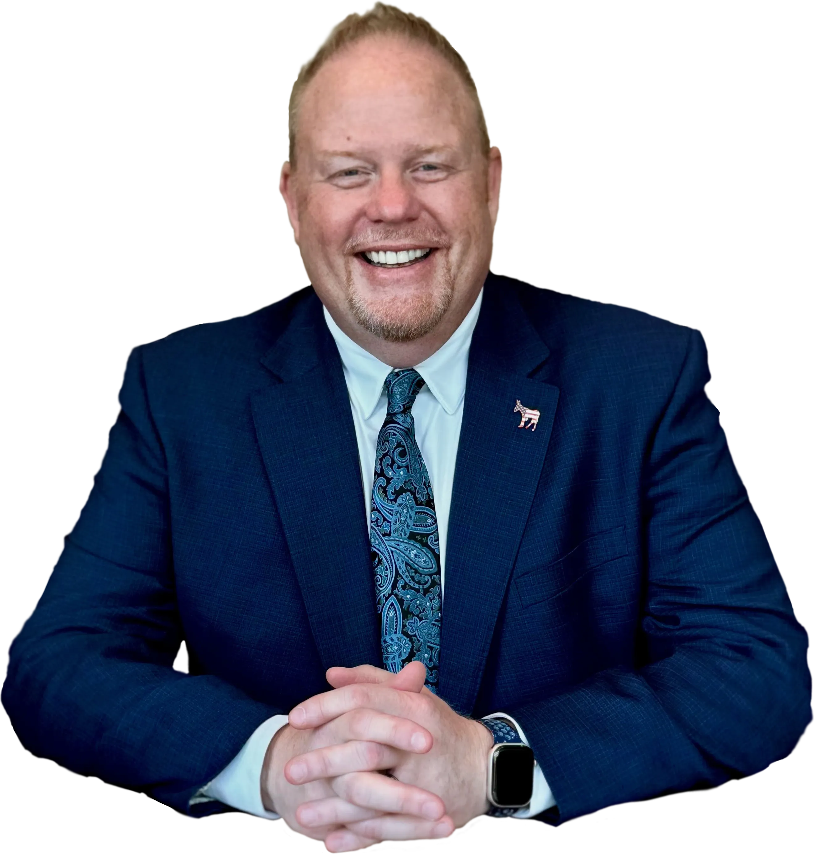 Danny Minton in a blue suit, smiling, with the United States Capitol behind him